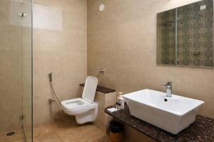 a bathroom with a sink and a toilet and a shower at Coffee Bean Inn in Bangalore