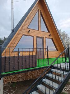 a house with a triangular roof and stairs at A frame iris in Filioara +4 photos