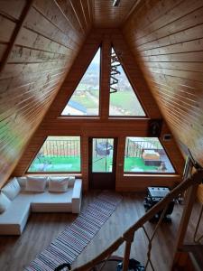 an attic room with a couch and windows at A frame iris in Filioara
