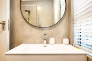 a bathroom with a white sink and a mirror at Beach Bliss Pad in Ballito +15 photos