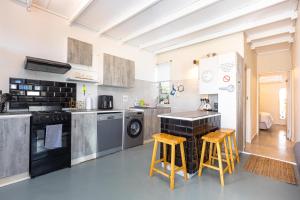 a kitchen with a counter and some stools in it at Beach Bliss Pad in Ballito