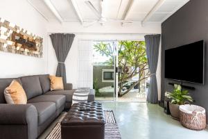 a living room with a couch and a tv at Beach Bliss Pad in Ballito