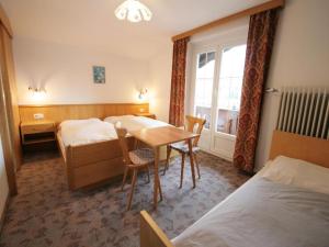 a hotel room with two beds and a table and chairs at Chalet Gamper by Summit Travel in Ellmau