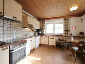 a kitchen with a table and a stove top oven at Chalet Gamper by Summit Travel in Ellmau