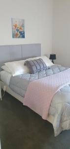 a large white bed with a pink blanket on it at Arbor Suite in Greytown