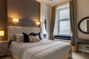 a bedroom with a large bed and a window at West Highland Apartments Milngavie - The Nevis in Milngavie +27 photos