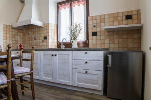 una cucina con frigorifero in acciaio inossidabile e lavandino di Chez Pépé Louis ad Aosta
