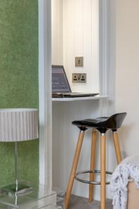 a table with a laptop on a counter with a stool at West Highland Apartments Milngavie - The Nevis in Milngavie
