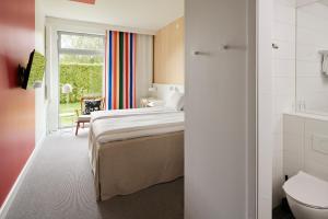 a hotel room with a bed and a bathroom at IKEA Hotell in Älmhult