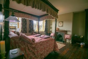 a bedroom with a canopy bed and a fireplace at The Brontë Birthplace in Thornton