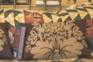 a bed with a pillow and books on it at The Brontë Birthplace in Thornton