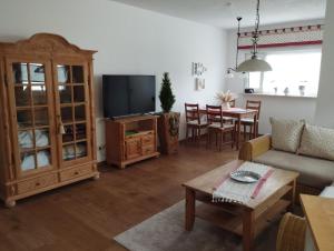 ein Wohnzimmer mit Sofa, Fernseher und Tisch in der Unterkunft Thüringer Pforte in Gorsleben