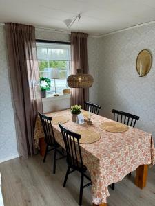 a dining room with a table with chairs and a window at Litet hus på landet in Krokom