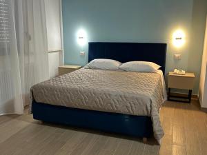 ein Schlafzimmer mit einem blauen Bett und zwei Kissen in der Unterkunft Hotel Nova in Varese