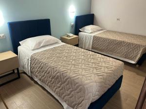 ein Hotelzimmer mit zwei Betten und zwei Tischen in der Unterkunft Hotel Nova in Varese