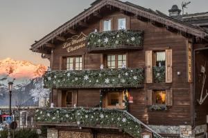 un bâtiment en bois avec des fleurs sur son côté dans l'établissement Les Monts Charvin, à Courchevel