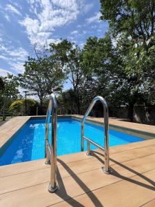 a pair of metal rails leading to a swimming pool at Bann Kieng Kiri Khaoyai บ้านเคียงคีรี เขาใหญ่ in Mu Si +7 photos