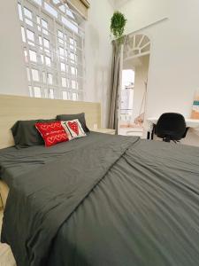 a bedroom with a bed with two red pillows on it at Mya's Homestay in Long Trường