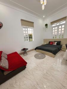 a bedroom with a bed and a couch and windows at Mya's Homestay in Long Trường