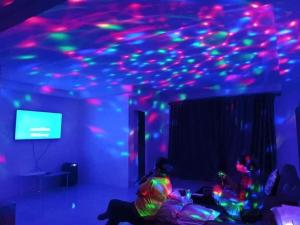 a person sitting on a couch in a room with lights on the ceiling at Baan Pink Pool Villa Pattaya in Ban Huai Yai +52 photos