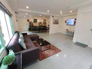 a living room with a couch and a table at Baan Pink Pool Villa Pattaya in Ban Huai Yai