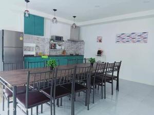 a kitchen with a wooden table and black chairs at Baan Pink Pool Villa Pattaya in Ban Huai Yai