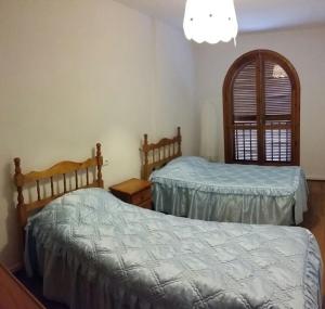 1 dormitorio con 2 camas y lámpara de araña en Calle Rafal, en Torrevieja