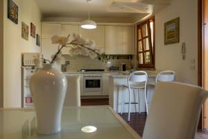 a kitchen with a vase sitting on a glass table at Villa Libo - HelloElba in Marciana Marina