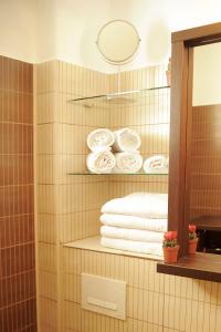 a bathroom with a shelf with towels and a mirror at Apartament Waldo 2 in Braşov