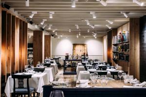 a restaurant with white tables and chairs and a bar at Hotel Maher in Cintruénigo