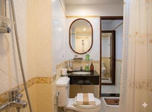 a bathroom with a toilet and a sink and a mirror at Chaba silom in Bang Rak