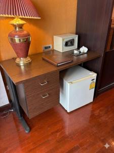 a desk with a microwave and a lamp on it at Chaba silom in Bang Rak