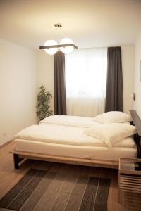 a bedroom with two beds in front of a window at Apartament Waldo 2 in Braşov