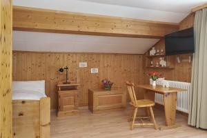 a bedroom with a bed and a desk and a table at Hotel Bad Serneus in Klosters