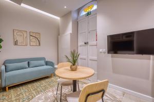 a living room with a blue couch and a table at NORFOLK Suites in Sliema