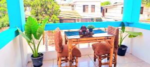 a table and chairs on a balcony with plants at Casa Galarous Island in Puerto Ayora