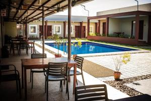 a restaurant with a table and chairs and a swimming pool at Sabine's Place in Cangbaliguia