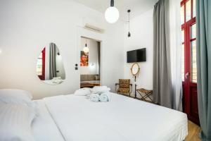 a bedroom with a white bed with towels on it at The Maroon Bottle Hotel in Thessaloniki