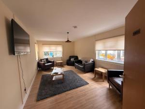 a living room with couches and a flat screen tv at Spacious House Sleeps 10 -Near BikePark Wales -Central -Parking in Troed-y-rhiw