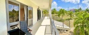 a balcony of a house with a view of a field at Korah house in Saint Philip