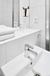 a white bathroom with a sink and a mirror at IKEA Hotell in Älmhult +18 photos