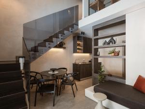 a living room with a staircase and a table and chairs at Grand Residences in Chania