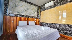a bedroom with a bed and a painting on the wall at Hotel View Sông Phú Quốc in Phú Quốc