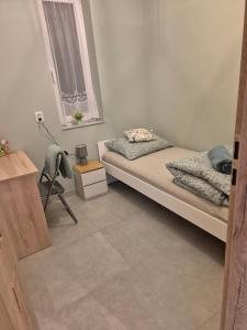 a small bedroom with a bed and a window at Apartament Pracowniczy in Mielec +1 photo