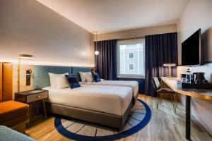 a hotel room with a large bed and a desk at voco Gent by IHG in Ghent +138 photos