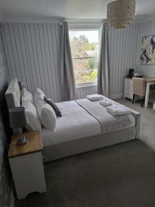 a bedroom with a large bed with a window at The Abbey Town House in Cheltenham