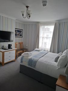 a bedroom with a bed and a desk and a television at The Abbey Town House in Cheltenham