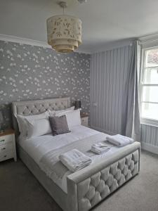a bedroom with a large white bed with white pillows at The Abbey Town House in Cheltenham