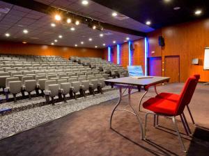 an empty lecture hall with a table and chairs at Mercure Quimper Centre in Quimper