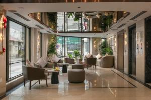 a lobby with couches and tables and windows at Hong Ngoc Cochinchine Boutique Hotel & Spa in Hanoi